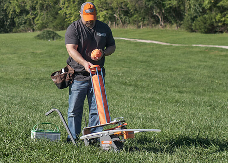 Man loading traps into Champion Workhorse Electronic Trap in field