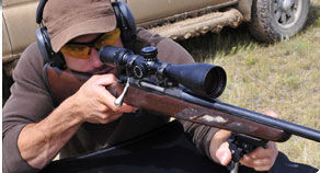 Man aiming rifle down range.